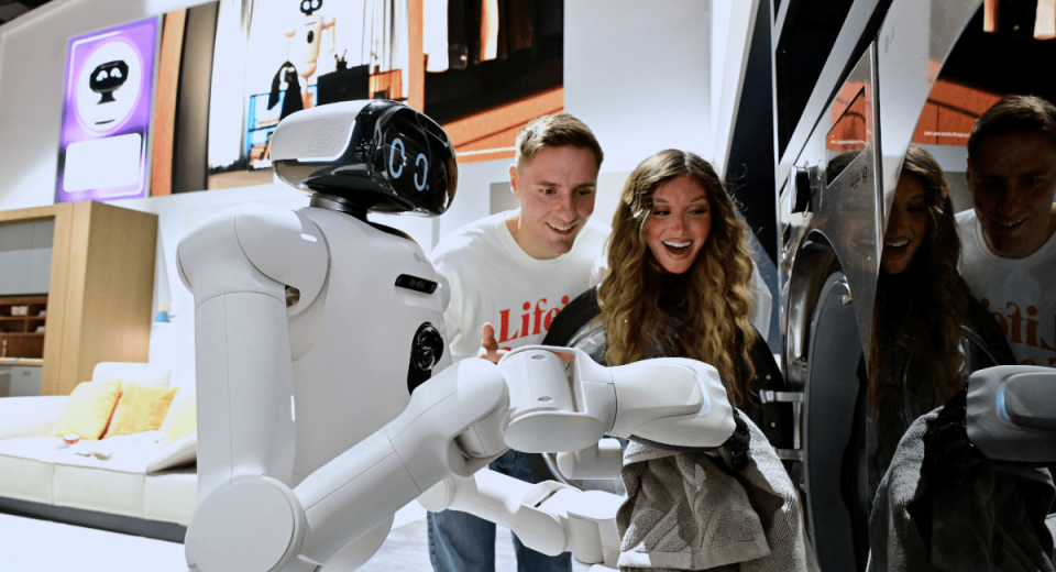 Robot LG CLOiD interactuando en una sala moderna con la pantalla OLED evo W6 Wallpaper.