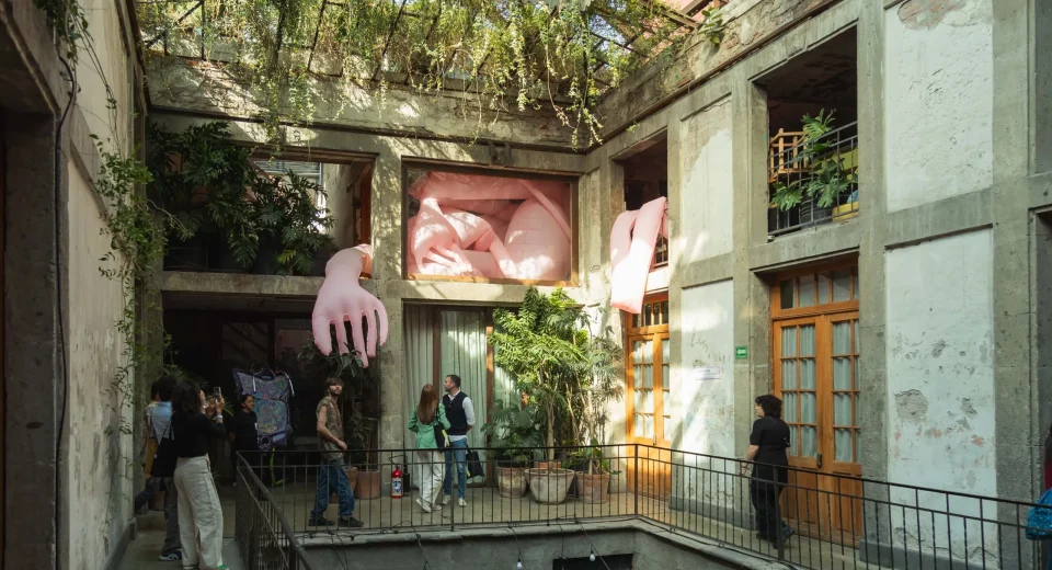 Exposición de arte contemporáneo en Salón ACME dentro de una casona antigua de la Colonia Juárez, con gente admirando obras modernas bajo luces cálidas y neones.