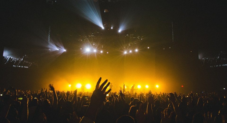 Público en un concierto en arena con luces de escenario, a la espera de los boletos José Madero CDMX